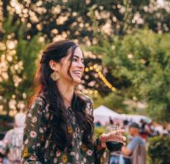 woman smiling holding glass of wine